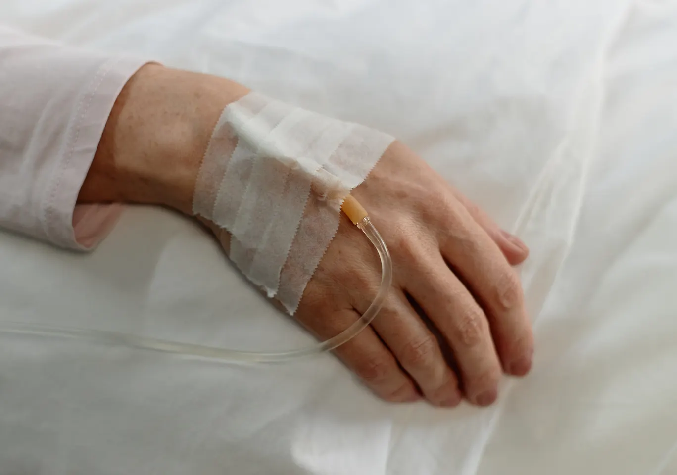Kroplówki witaminowe Nowa Dęba: dłoń z podłączoną kroplówką w spokojnym kadrze